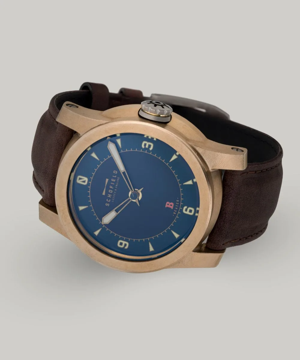 The B3 ✦ Raw Bronze wristwatch with a raw bronze case, blue dial, and tan hour markers with a numerals at 3,6,9 and 12. A small Sign-of-Life seconds hand can be seen in the centre.