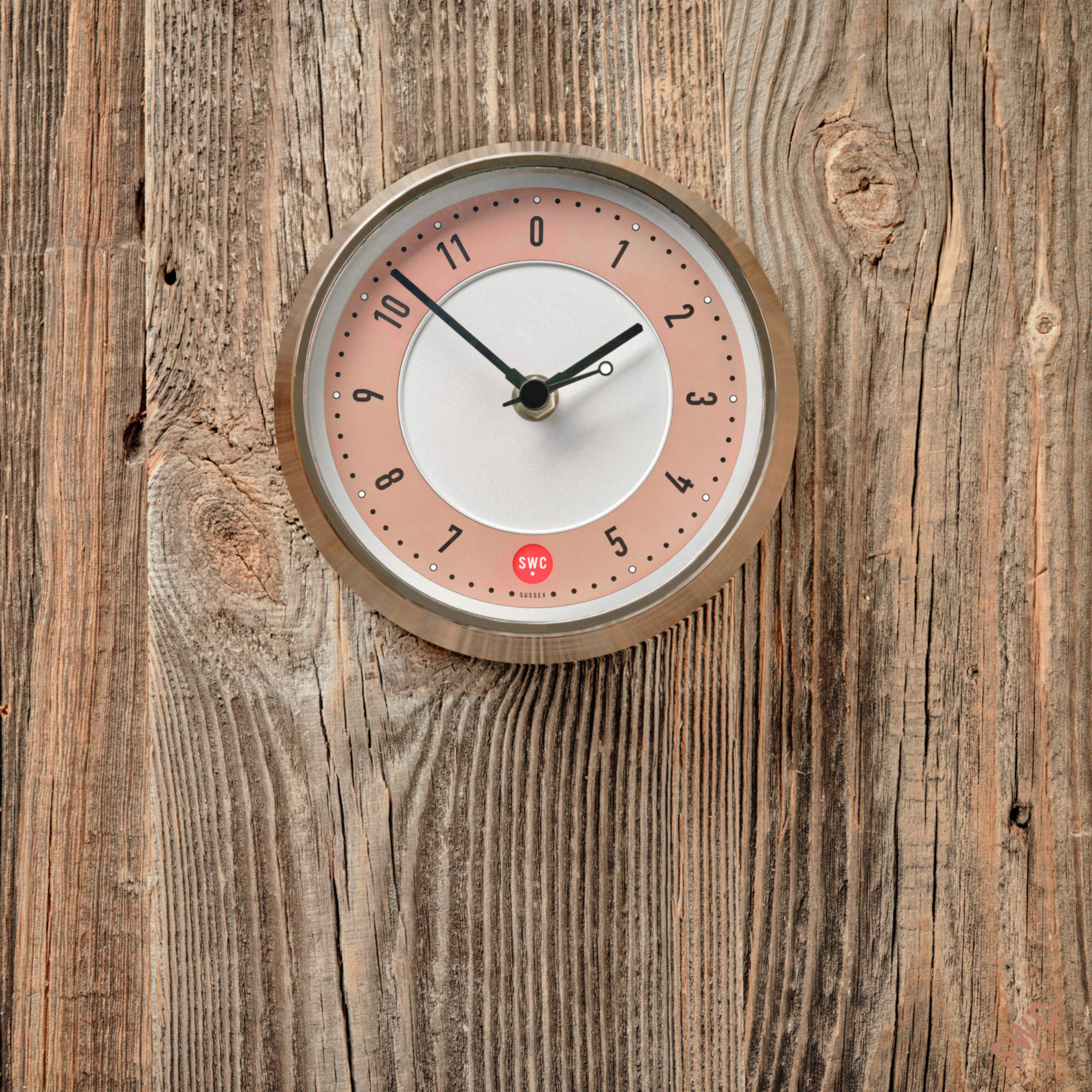 Pink wall clock on wood