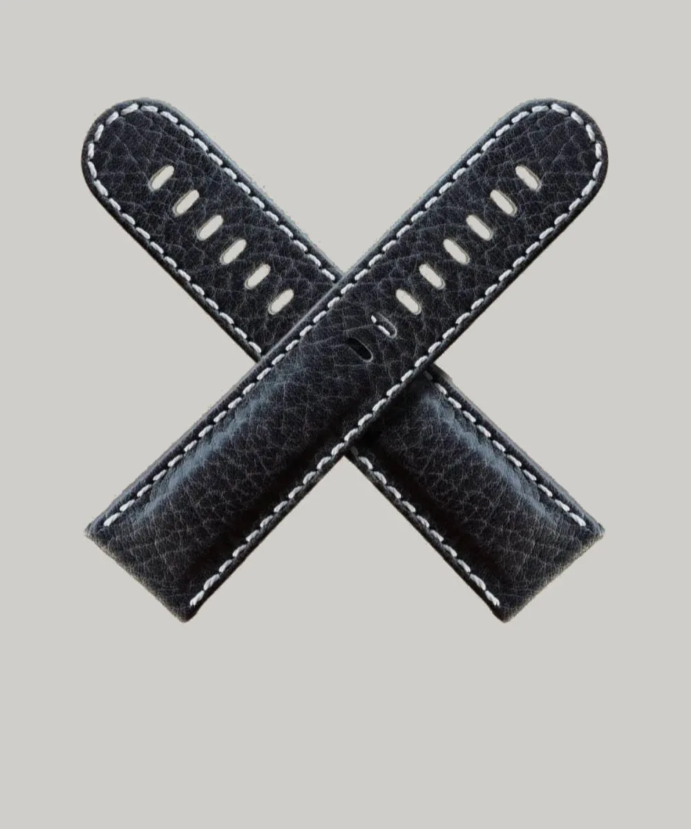 Two Black Buffalo watch straps with white stitching are crossed in an "X" shape against a light gray background. Each strap has multiple holes for adjustment.