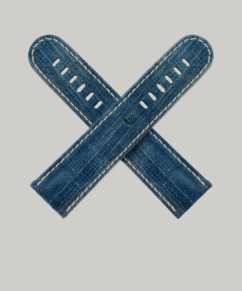 Two Japanese indigo watch straps crossed over each other. The straps are made of an indigo dyed Japanese Indigo canvas, with white stitching along the edges and multiple holes for adjusting the fit.