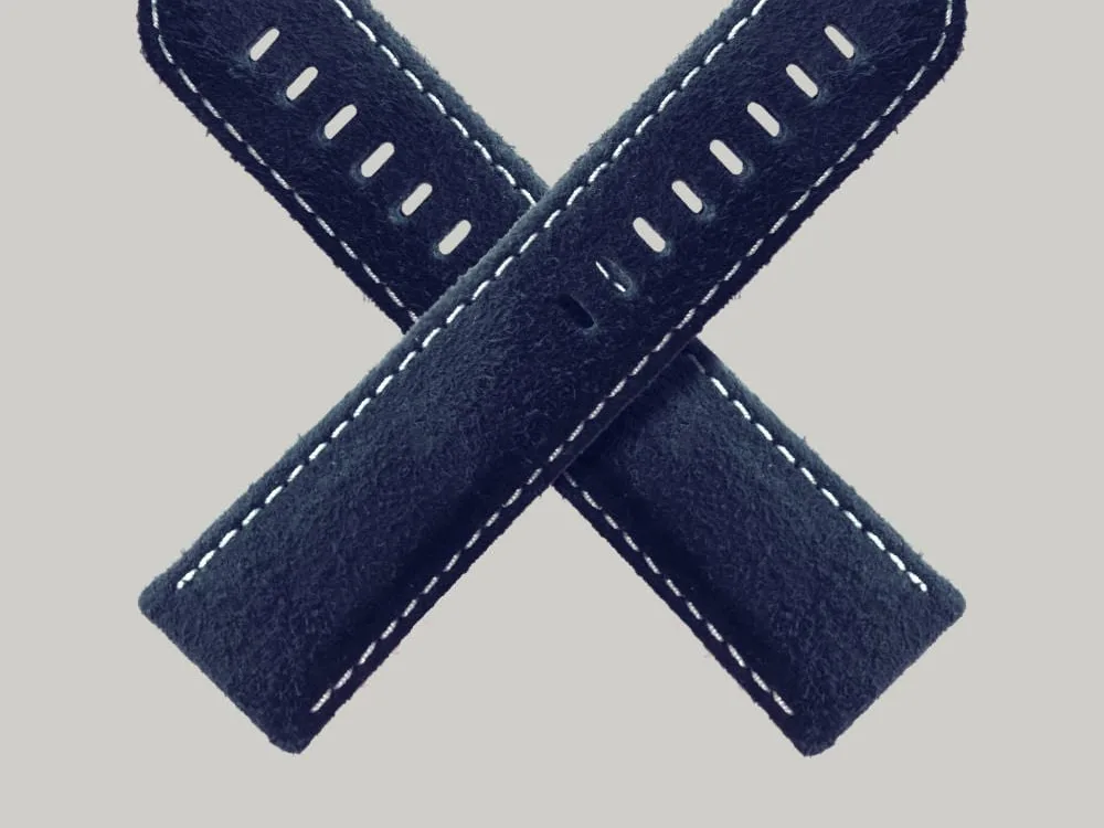 A dark blue tweed watch straps crossed in an 'X' shape against a light grey background. The strap is a refined Moon's fabric and features white stitching along the edges and multiple holes for adjustable sizing.