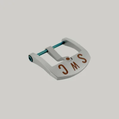 A Brushed BE Buckle with a rectangular frame and blue PVD strap fitting screw. The thumbnail style buckle, called The Best Ever Buckle, features the engraved letters "SWC" in a red paint fill.