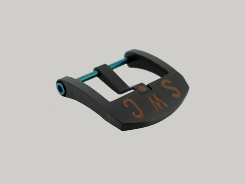 A Black DLC BE Buckle with a blue PVD strap fitting screw. The thumbnail style buckle, called The Best Ever Buckle, features the engraved letters "SWC" in a red paint fill.