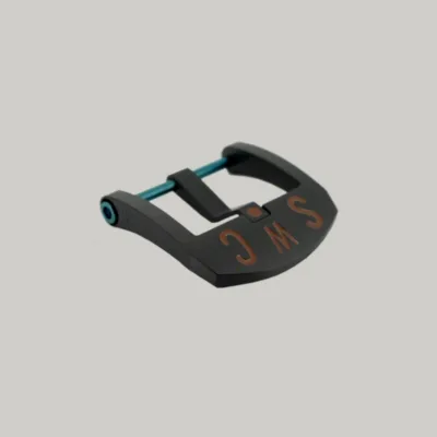 A Black DLC BE Buckle with a blue PVD strap fitting screw. The thumbnail style buckle, called The Best Ever Buckle, features the engraved letters "SWC" in a red paint fill.