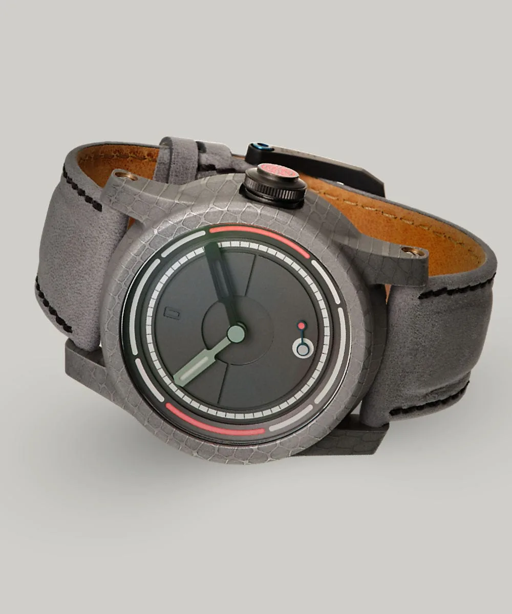 The British made, unique designed, minimal Obscura watch lying on its side showing the Damascus steel case and lume crown.