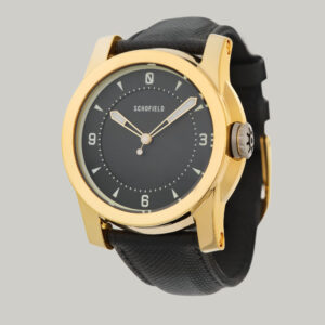 A polished gold-plated Treasure Watch ✦ Gold with a black leather strap. This treasure watch features a black minimal dial with Super-LumiNova markings and hands, including numerals at 3, 6, 9, and 12.