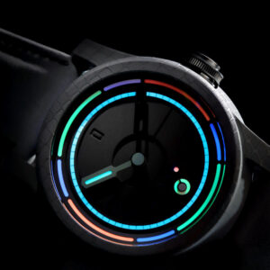 A close-up shot of a wristwatch with a dark face and a sleek, modern design. The watch features vibrant, colorful neon-like light accents in blue, green, red, and orange around the perimeter and in circular patterns on the watch face against a black background.