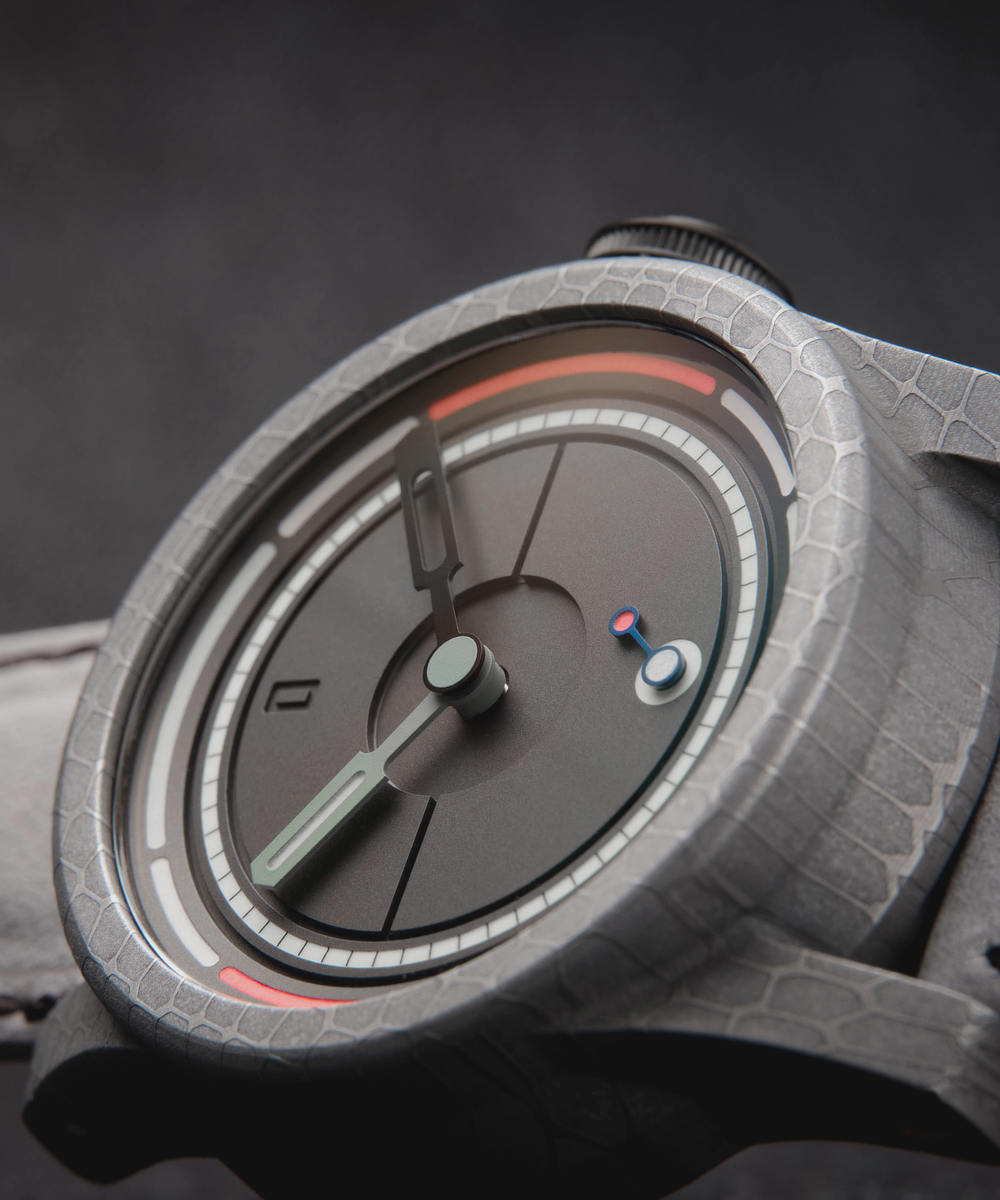 Close-up image of a modern wristwatch with a minimalist design. The watch has an Obscure matte black dial with green hour and black minute hands, a small red and blue second hand. The textured grey case and strap enhance its sleek, contemporary look.