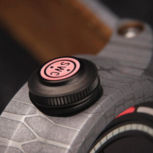 Close-up image of the Obscura watch crown with a textured Black DLC surface and a red circular filled cap labeled “SWC”.