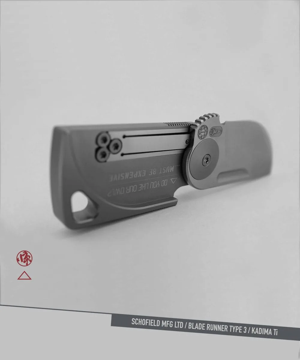 A sleek, grey folding knife with a minimalist design, unfolded on a grey surface. Branding and labels are visible, including “BLADE RUNNER TYPE 3 / KADIMA Ti” at the bottom.