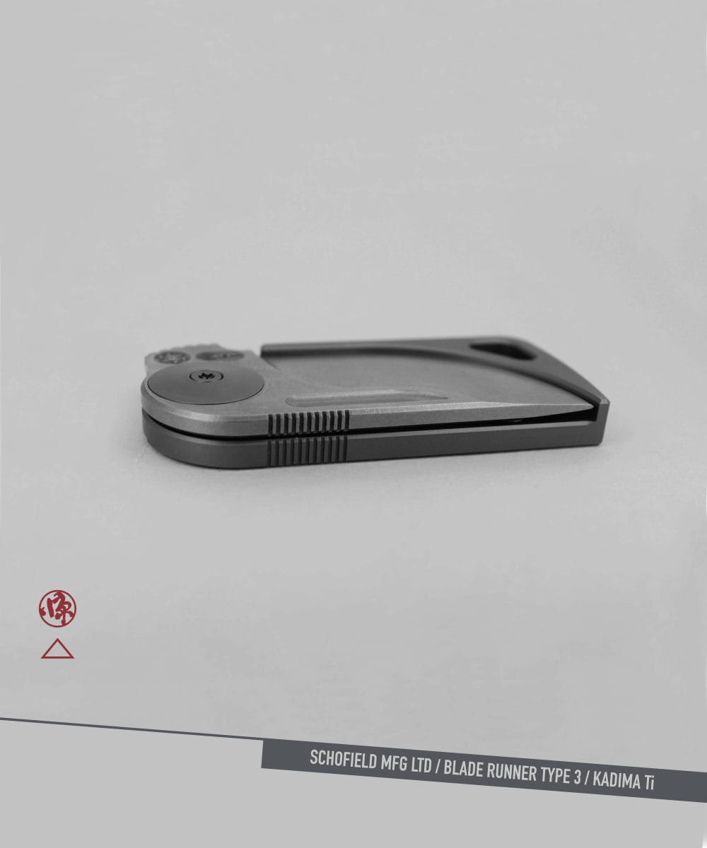 Blade Runner type 3 A sleek, modern folding knife with a metallic finish is displayed closed on a light gray background. The text at the bottom reads "SCHOFIELD MFG LTD / BLADE RUNNER TYPE 3 / KADIMA Ti.