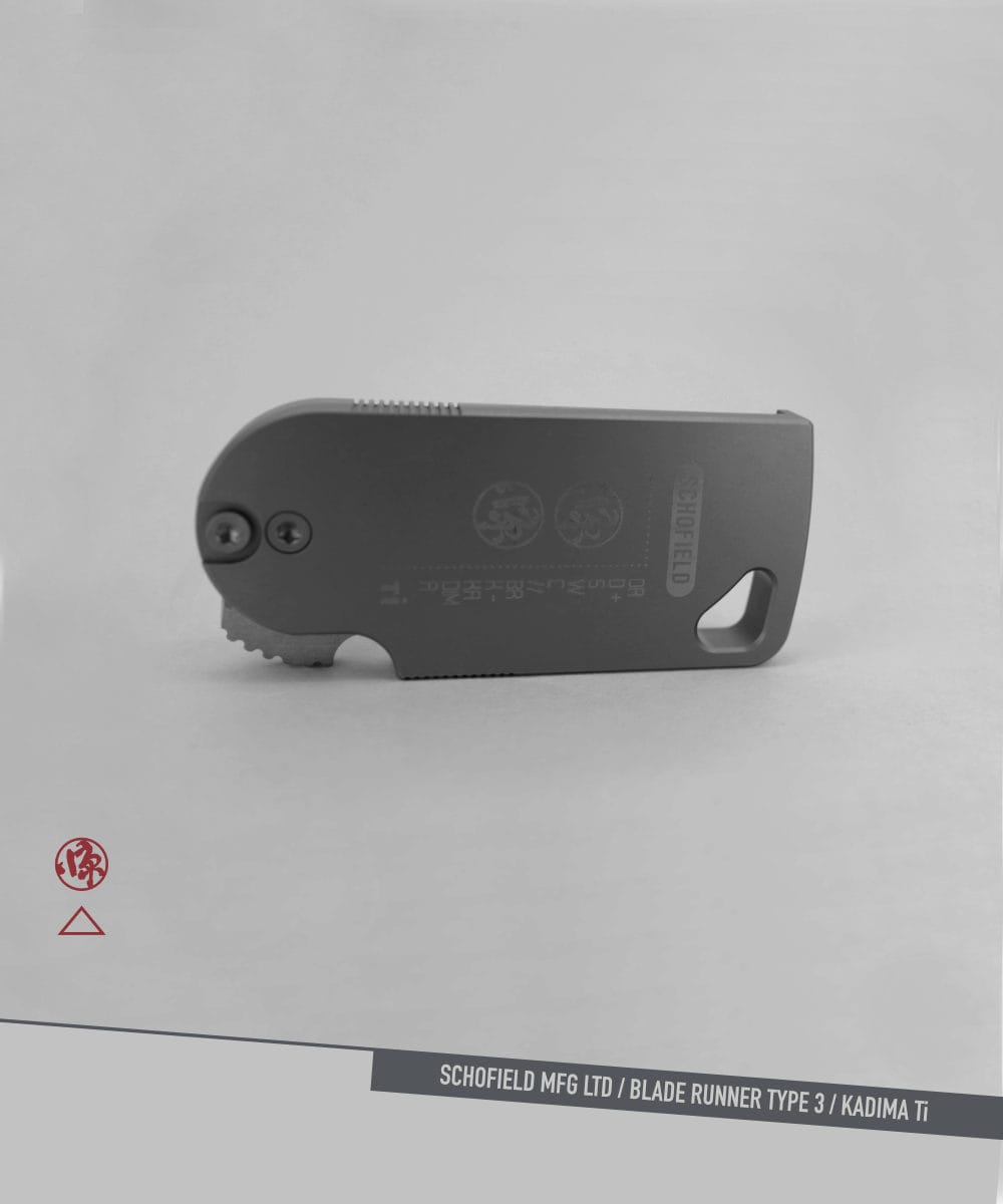 Blade Runner Knife Titanium A compact, foldable utility knife with a gray metal body lies on a light surface. The words "SCHOFIELD MFG LTD / BLADE RUNNER TYPE 3 / KADIMA Ti" are printed along the bottom edge of the image.