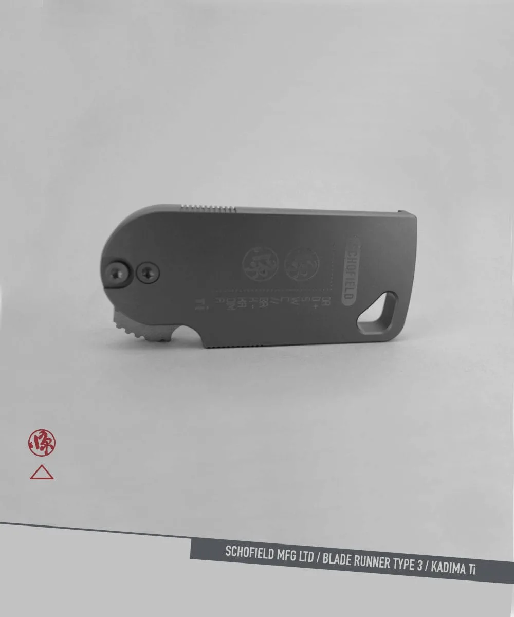 A compact, foldable utility knife with a gray metal body lies on a light surface. The words "SCHOFIELD MFG LTD / BLADE RUNNER TYPE 3 / KADIMA Ti" are printed along the bottom edge of the image.