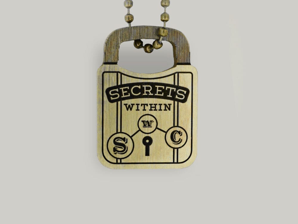Brass padlock keyring A padlock-shaped brass key ring with "Secrets Within" written on it by Schofield Watch Company