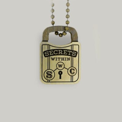 Brass padlock keyring A padlock-shaped brass key ring with "Secrets Within" written on it by Schofield Watch Company