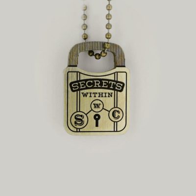 A brass Schofield padlock design keyring that reads Secrets Within