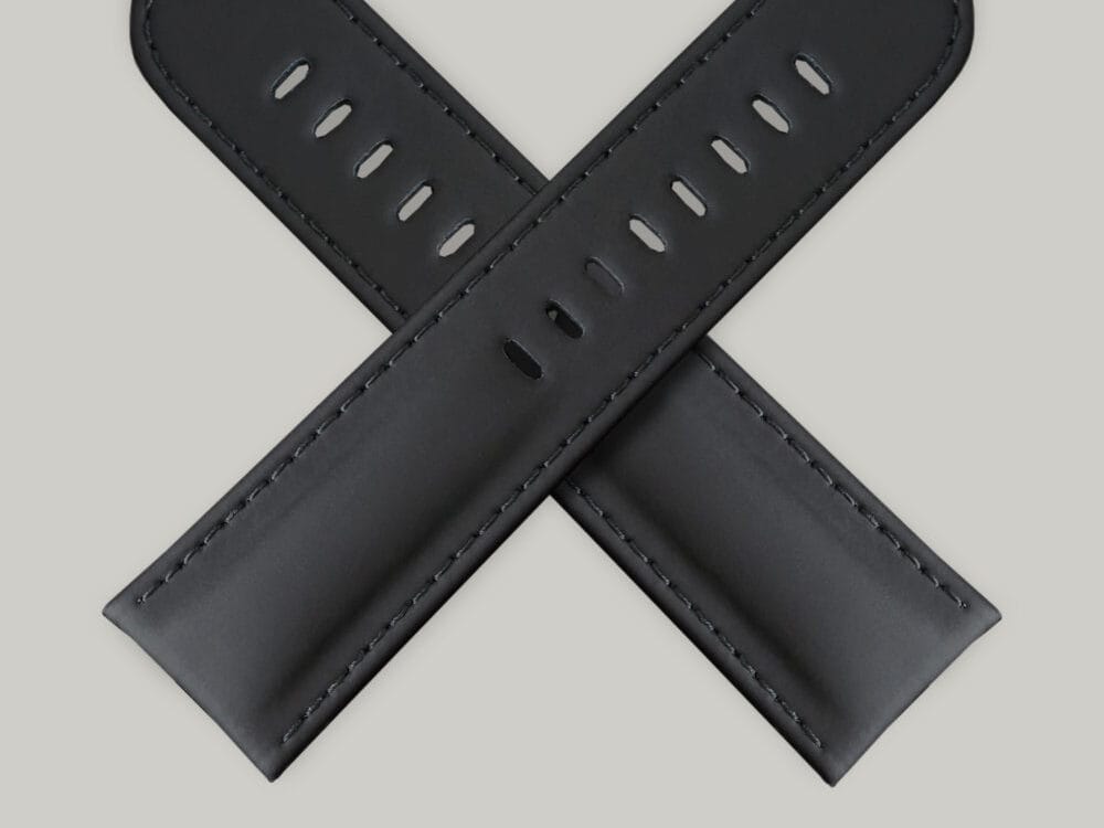 A pair of black India Rubber watch straps. The straps have multiple holes for adjusting the fit The sticking is black.