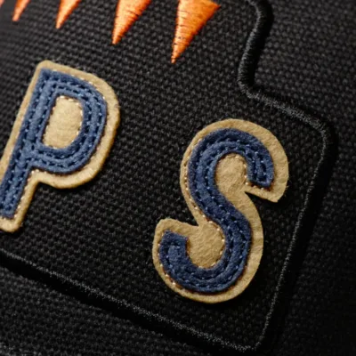 A close up of some letters applied to the front of the Black 6 Pips cap
